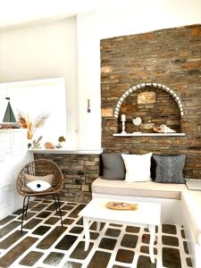 a living room with a couch and a brick wall at Aegeo Inn in Antiparos