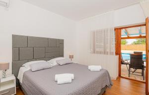 una camera da letto con un letto con due asciugamani bianchi di 4 Bedroom Awesome Home In Sibenik a Piramatovci Altre 33 foto