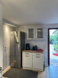 ヴァイブルクにあるFerienwohnung Lahntalblickのキッチン(ステンレス製の冷蔵庫、白いキャビネット付)