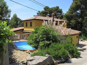 a house with a swimming pool in front of a house at Holiday Home Yellowhouse in Kaštel