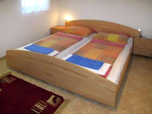 a large wooden bed in a room with at Holiday Home Yellowhouse in Kaštel +6 photos