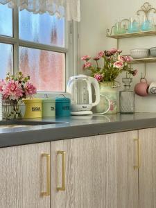 a kitchen counter with flowers and a appliance on it at Suits יחידת נופש מתוקה באילת in Eilat +10 photos