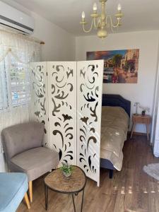 a bedroom with a bed and a chair and a table at Suits יחידת נופש מתוקה באילת in Eilat