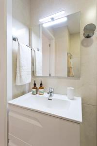 Un baño con un lavabo blanco y un espejo. en Casa Roberto - Studio Apartment, Lift, AC, Car Parking - extra, en Oporto