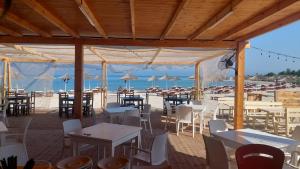 a restaurant on the beach with tables and chairs at Apartments Rezidenca Sinani Orikum in Orikum +98 photos
