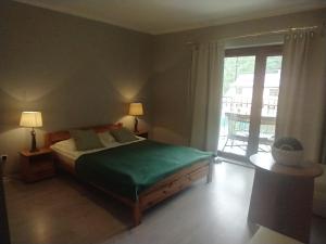 a bedroom with a bed and a sliding glass door at Korab Wisełka & SPA in Wisełka +222 photos