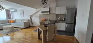 Una cocina y una sala de estar con una mesa y un sofá. en Central Apartments in Skopje, en Skopje 6 fotos más