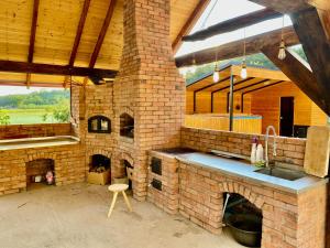 an outdoor kitchen with a large brick oven at Casa David 13D in Nimăeşti