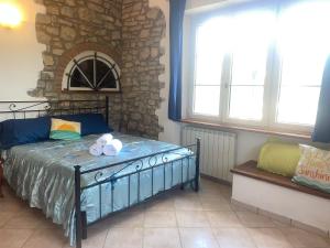 a bedroom with a bed and a stone wall at Sunshine in Sanfatucchio