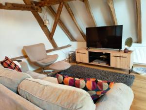 a living room with a couch and a flat screen tv at B&B In de Roos in Lottum