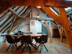 a dining room with a wooden table and chairs at B&B In de Roos in Lottum