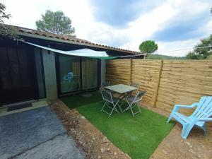 taras ze stołem, krzesłami i płotem w obiekcie Petite Maison de vacances w mieście Tourrettes