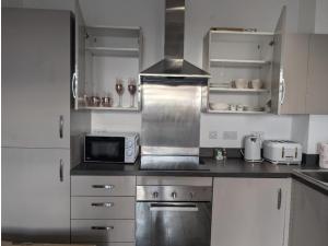 a kitchen with a stove and a microwave at The Station HomeStay in Rugby