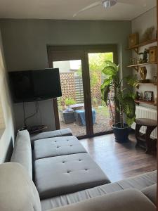 a living room with a couch and a flat screen tv at Apartament ZIELONY TARAS in Kielce