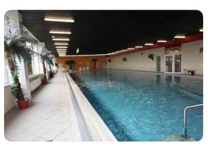 ein großes Schwimmbecken mit blauem Wasser in einem Gebäude in der Unterkunft Hohegeiß Ferienwohunung - 14ter Etage mit Blick in Braunlage