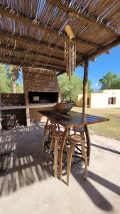 a wooden table and chairs under a wooden pergola at La huella Jáchal - Casas de Campo in San José de Jáchal