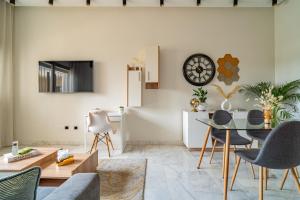 a living room with a table and a clock on the wall at AeroSuite in Nouaceur