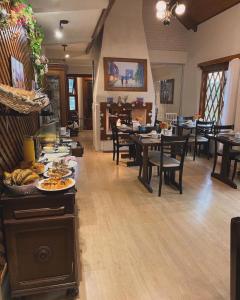a dining room with tables and chairs with plates of food at Pousada dos Pássaros in Gramado +37 photos
