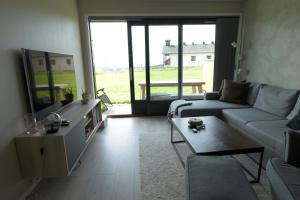 a living room with a couch and a table at Lys og moderne leilighet rett ved skiløypa på Nordseter - Kort vei til Sjusjøen, Lillehammer og Hafjell - Dyr ikke tillatt in Nordseter