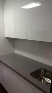 a kitchen with a sink and white cabinets at Apartamento moderno en el centro Vilagarcia in Vilagarcia de Arousa