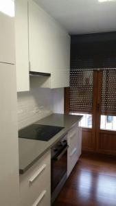 a kitchen with white cabinets and a black counter top at Apartamento moderno en el centro Vilagarcia in Vilagarcia de Arousa