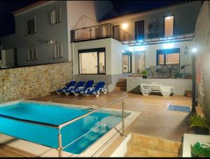 a house with a swimming pool and a living room at Casa da Aldeia in Santa Clara-a-Nova