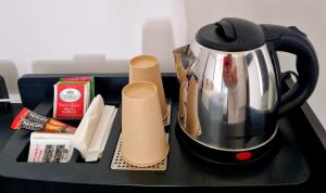 a tea kettle on a black tray withacist at Mi Garba B&B in Viareggio