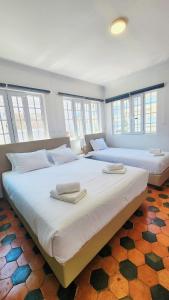 two large beds in a room with windows at Vila Olivença in Costa da Caparica