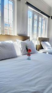 Una cama blanca con una planta encima en Vila Olivença, en Costa da Caparica