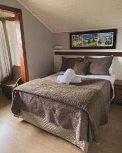 a bedroom with a large bed in a room at Pousada dos Pássaros in Gramado