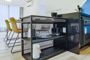 a black desk with two yellow chairs in a room at HomeCO - Conforto na esqui praia in Niterói