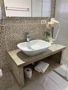 a bathroom with a large white bowl sink on a counter at Pousada dos Pássaros in Gramado