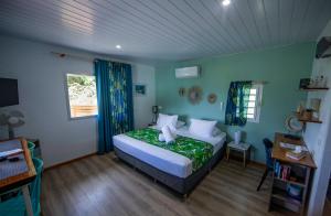 a bedroom with a bed in a room with blue walls at Morning Sun Place Tahaa in Taha’a