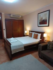 a bedroom with a large bed and a couch at Villa Roselina By Beatrix in Budva