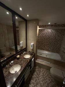 a bathroom with two sinks and a toilet and a tub at Flat Luxo Mountain Village in Canela +31 photos