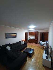 a living room with a black couch and a table at Villa Roselina By Beatrix in Budva