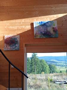 two paintings on the wall of a cabin with a window at Cisza & Natura - Kraina Wygasłych Wulkanów in Radzimowice