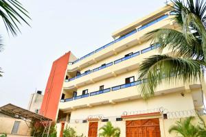 a building with blue windows and palm trees at Détente dans un environnement paisible in Lomé