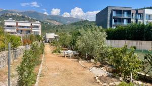 a garden with trees and a building in the background at Little Paradise Livadi Himare in Himare