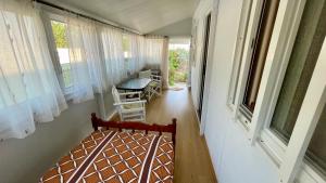 a room with a bed and a table and windows at Little Paradise Livadi Himare in Himare