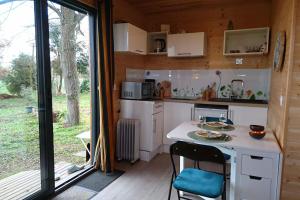 a kitchen with a counter and a table in a cabin at Évasion nature - Tiny house in Baziège