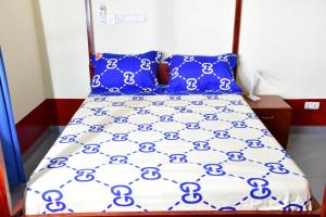a bed with blue and white sheets and blue pillows at Détente dans un environnement paisible in Lomé