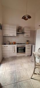 a kitchen with white appliances and a tiled floor at Casa dei bagnanti sul Porto Vecchio in Stintino