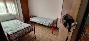 a room with two beds and a fan at Casa dei bagnanti sul Porto Vecchio in Stintino