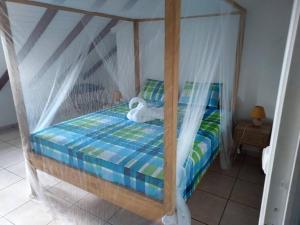 a bedroom with a canopy bed with a stuffed animal on it at Sunshine Villa in Pointe-Noire