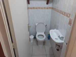 a small bathroom with a toilet and a sink at Sunshine Villa in Pointe-Noire +14 photos