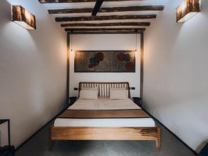 ein Schlafzimmer mit einem Bett in einer weißen Wand in der Unterkunft BaraBara Eat&Sleep in Paje