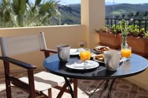 a table with food and orange juice on a balcony at Valley View House in Anópolis