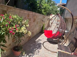 a hammock sitting on a patio next to some plants at Мансарда in Nesebar