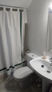 a bathroom with a white toilet and a sink at Duplex convento la victoria in Sanlúcar de Barrameda